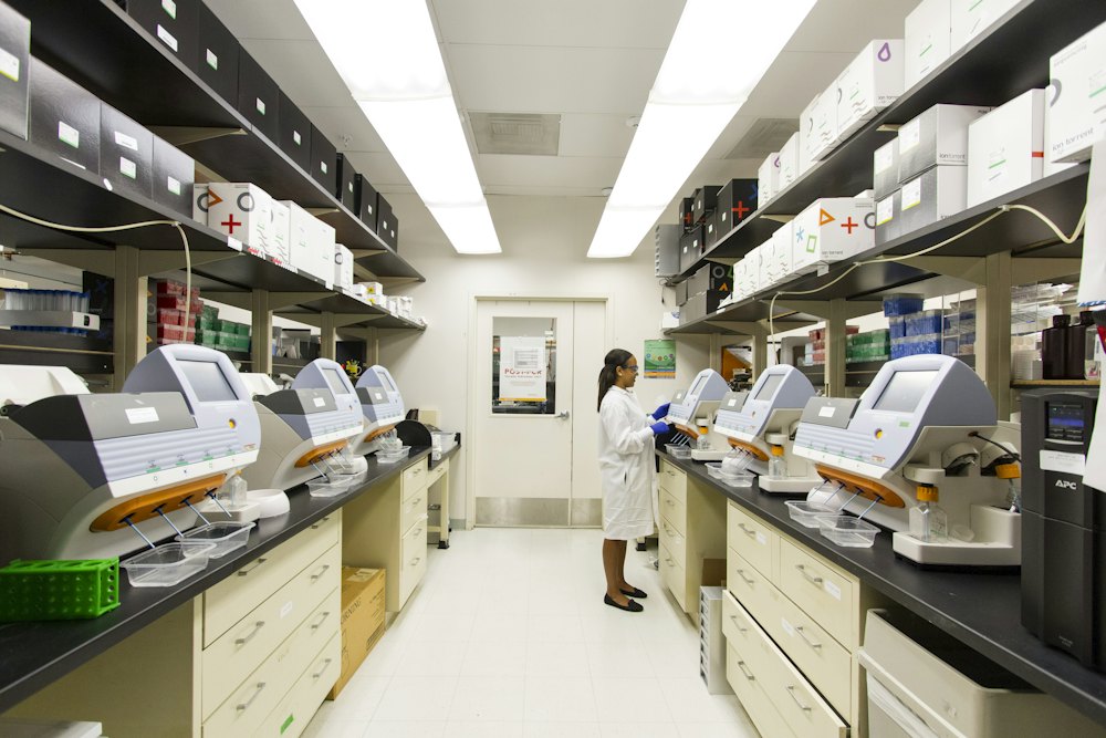 A researcher working along a corridor of analytical laboratory instruments