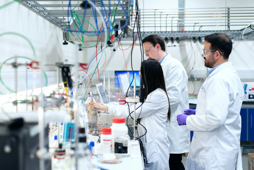 Researchers in lab coats working together at laboratory instruments