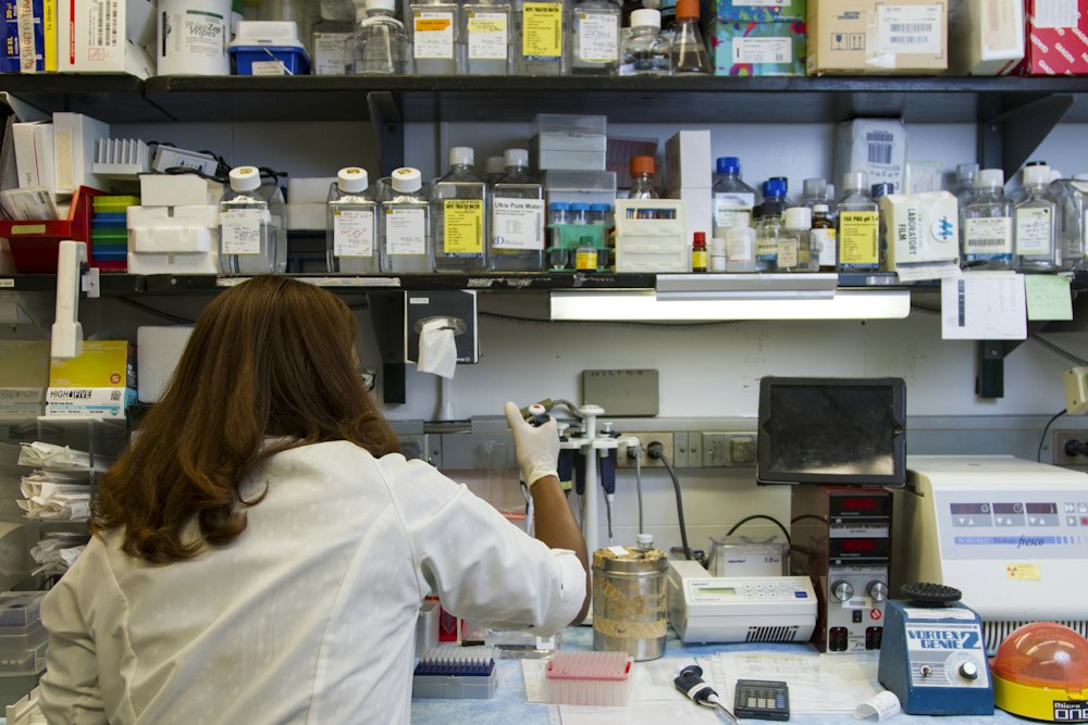 A researcher working at a laboratory bench surrounded by reagents and instruments